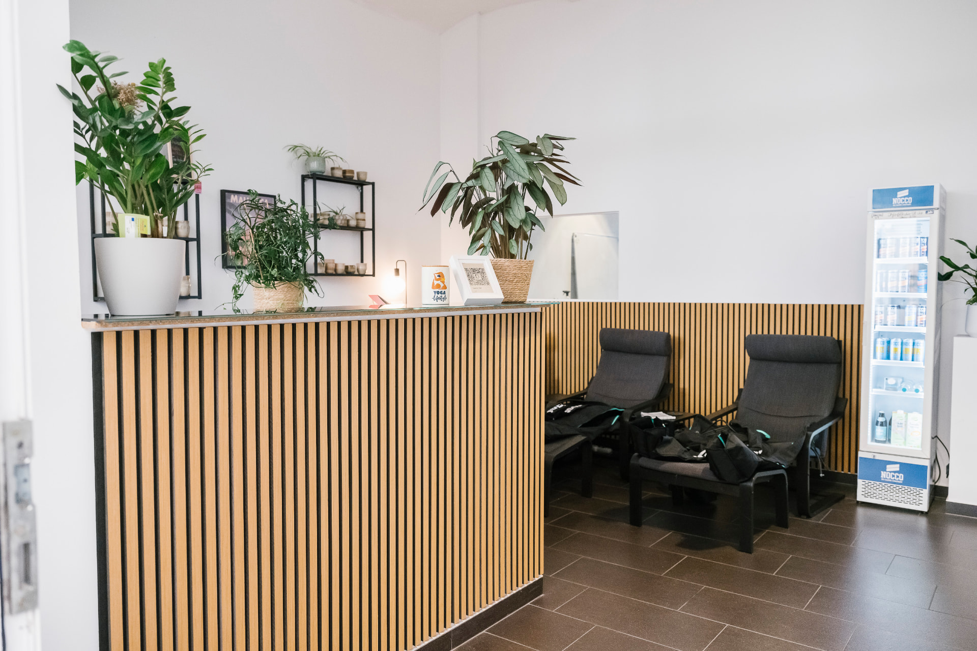 The Studio 58 lounge with the Reboots Recovery Pants area — wooden slat wall, plants and seating